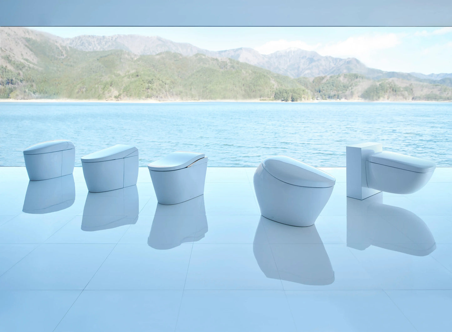 Row of TOTO NEOREST integrated bidet toilets displayed beside an infinity pool with a mountain backdrop
